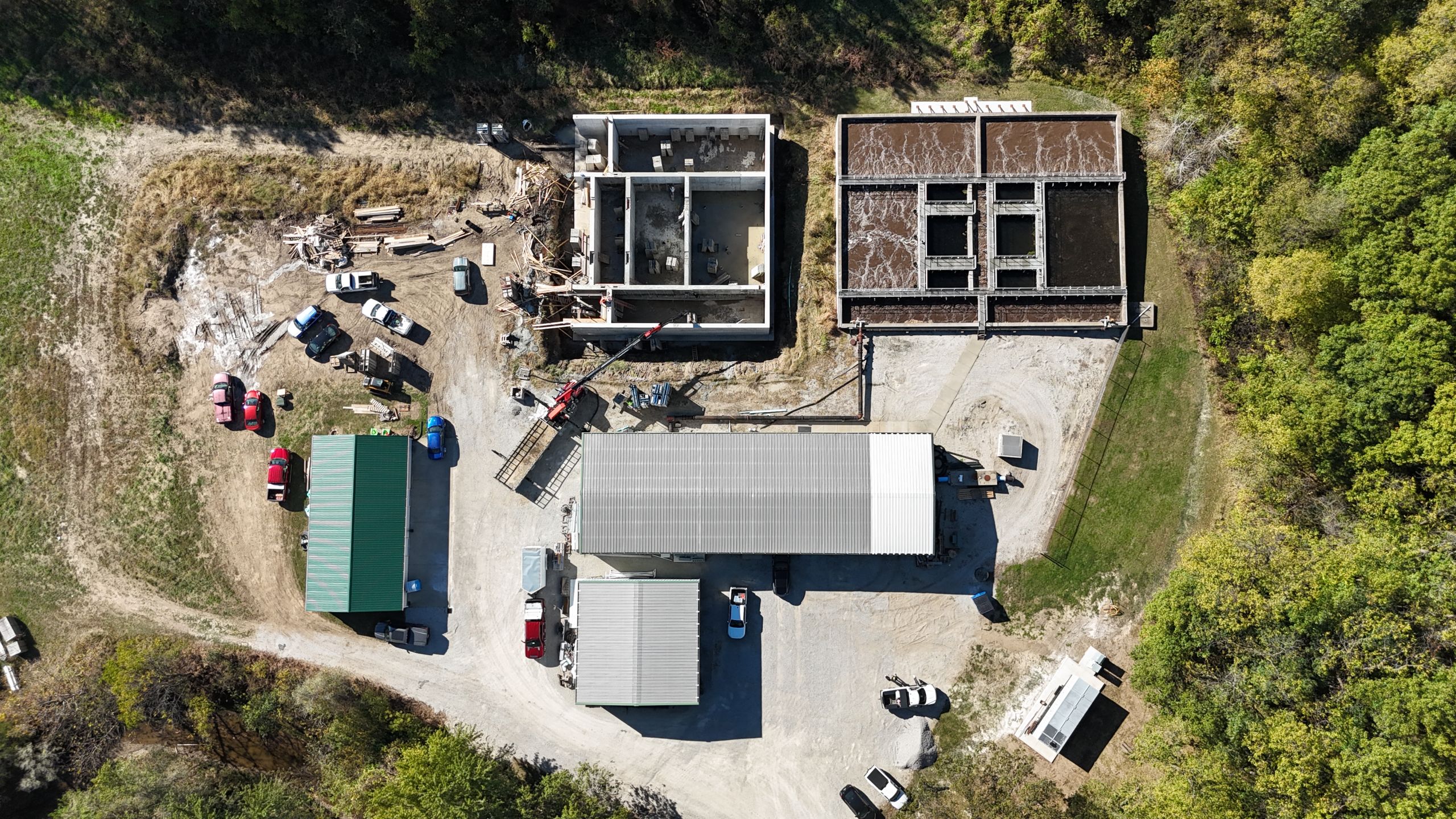 Aerial view of Havens industrial construction site featuring concrete foundation work, wastewater treatment tanks, and metal warehouse facilities.
