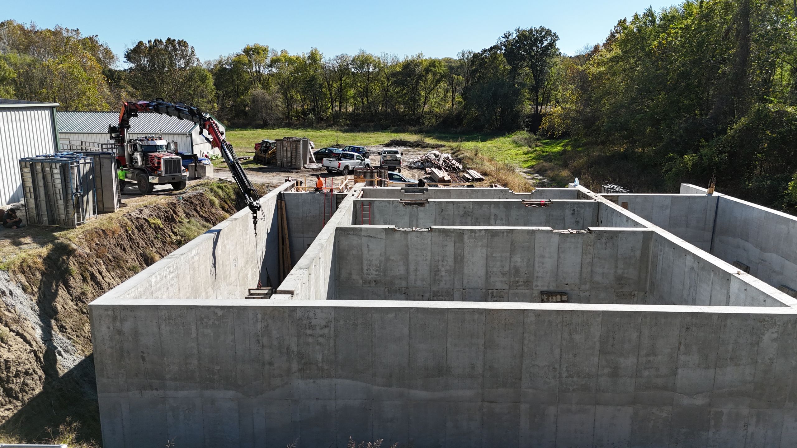 Ground-level view of the Timber Creek Wastewater Treatment plant construction in Kansas City, featuring a crane truck and large concrete foundation walls by Havens.