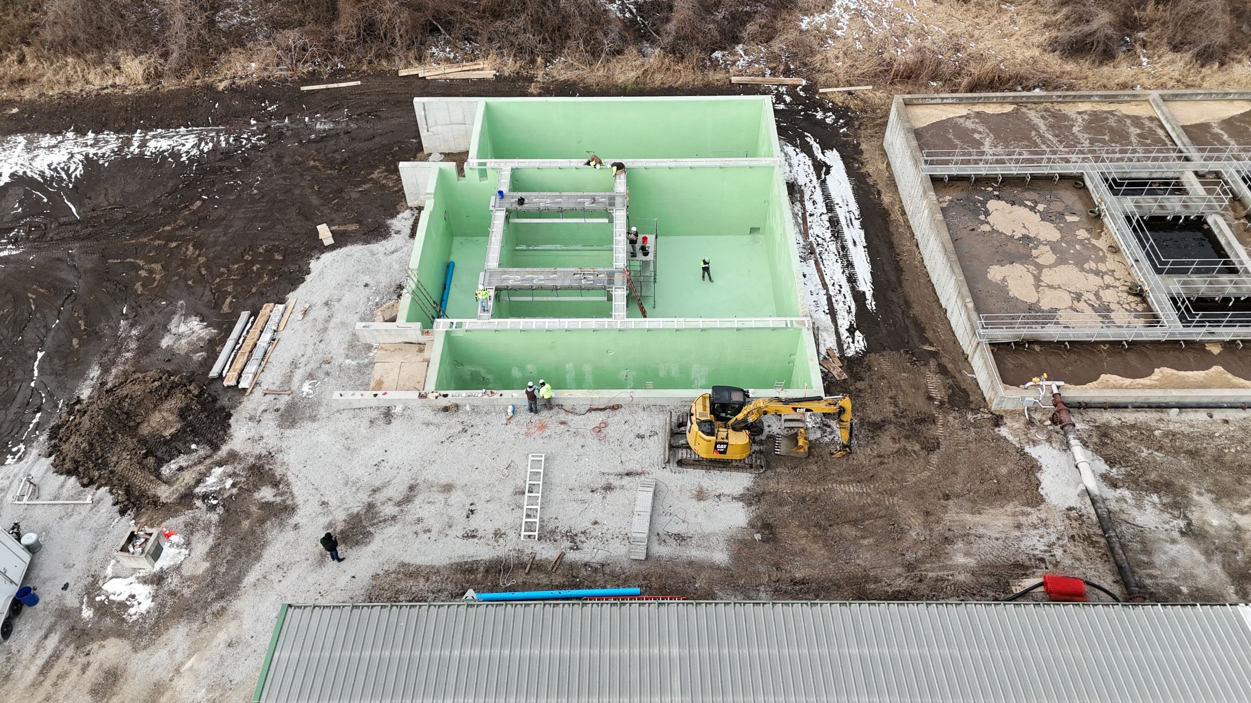 Aerial view of the Timber Creek Wastewater Treatment plant construction featuring green-lined concrete tanks and active excavation by Havens.